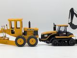 two toy construction vehicles that are sitting next to each other