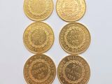 six gold coins with different designs on them on a white surface