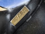 a close up of a black vase with a gold label on it