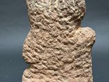 an ancient stone statue of a woman with her head turned to the side