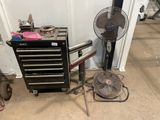 a fan that is sitting next to a tool box