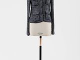 une veste en tweed noir et blanc posée sur un mannequin