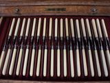 a wooden box filled with many different types of knitting needles