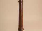 an image of a wooden pedestal with a marble top on a beige background