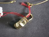 a necklace with a gold lock on a red string