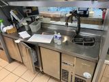 a kitchen with a sink and a counter with a lot of items
