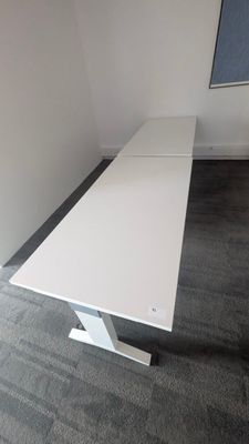 a white table in a room with a blackboard on the wall