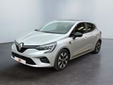 Une voiture blanche est garée dans une pièce au sol noir.