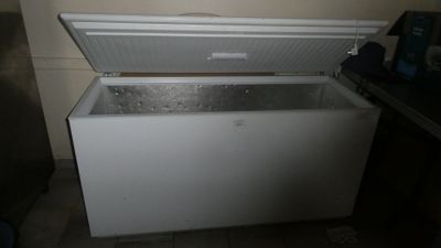 a white chest freezer sitting in the corner of a kitchen