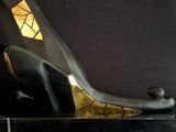 a black and gold sculpture of a cat on a black base