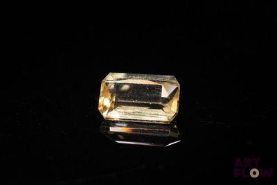 a close up of a yellow diamond on a black surface