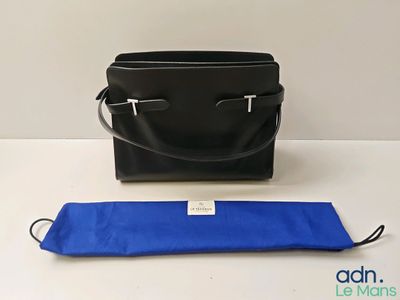un sac à main noir et un sac bleu posés sur une table