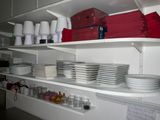 many plates and cups on the shelves in the kitchen