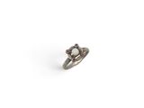 a silver ring with a white stone surrounded by red stones
