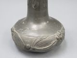 un vase en argent orné d'un motif, posé sur une table