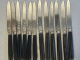 six couteaux sont alignés sur une table