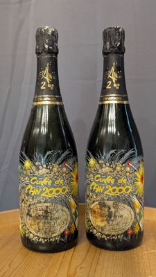 two bottles of champagne sitting on top of a wooden table