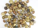 un gros plan sur une pile de boutons posés sur une surface blanche