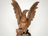 an image of a statue of a bird on a wooden base