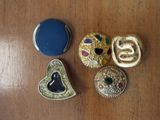 four different types of brooches on a wooden surface