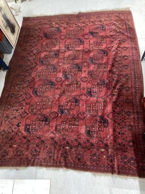 un grand tapis rouge posé au sol, à côté d'une chaise