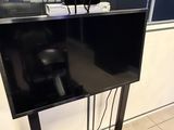 un téléviseur à écran plat posé sur un support dans une pièce