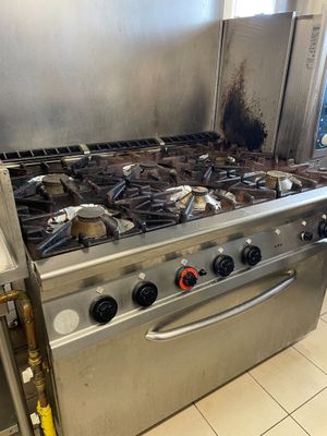 une cuisinière sale dans une cuisine où il y a beaucoup de rouille
