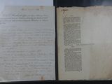 un vieux livre dont une page est couverte d'écriture, posé sur une table
