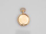 a close up of a gold pocket watch on a white surface