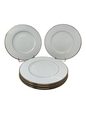 four white plates stacked on top of each other on a white surface