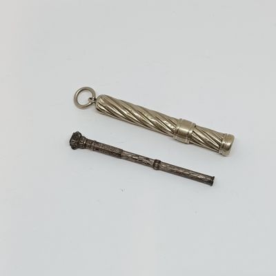 un petit objet métallique posé à côté d'un autre petit objet métallique