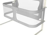 grey and white baby crib with a baby bed attached to it ' s side