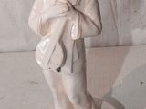 une figurine représentant un homme tenant un sac