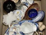 une boîte remplie d'assiettes, de tasses et de soucoupes en porcelaine