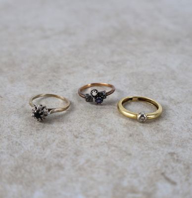 trois anneaux de couleurs différentes posés sur une surface blanche