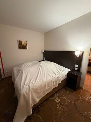 a bed with a white blanket on it in a room