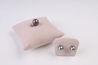 une paire de boucles d'oreilles posée sur un oreiller, à côté d'un autre oreiller