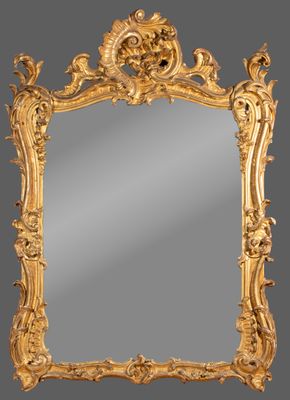 an ornate gold framed mirror with a bird and flower decoration