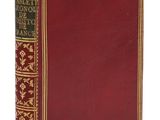 un vieux livre à la couverture rouge et à la bordure dorée