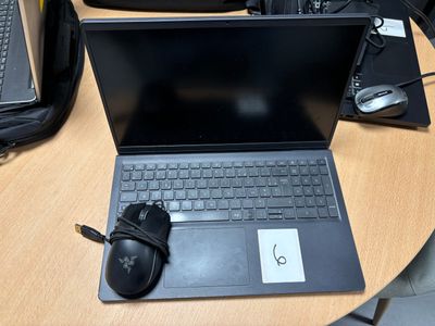 un ordinateur portable posé sur une table, avec une souris à côté