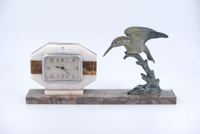 une statue représentant un oiseau et une horloge posée sur un socle