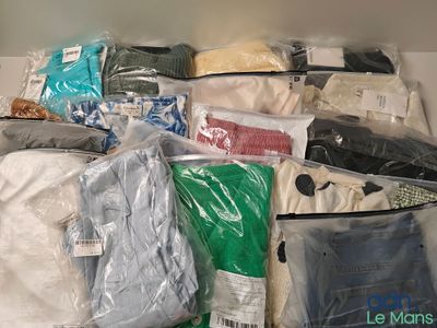 de nombreux sacs de vêtements posés sur une étagère