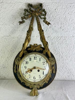 une horloge accrochée au mur, ornée d'un nœud