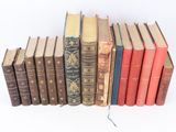 several old books are lined up in a row on a white surface