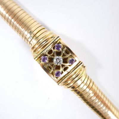 une image représentant un stylo en or orné de pierres violettes et blanches