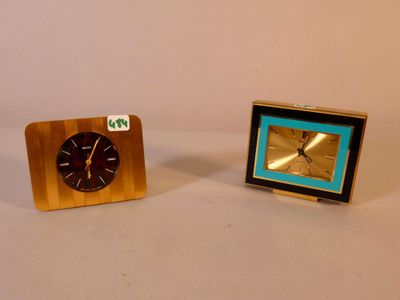two clocks sitting next to each other on a table