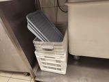 a stack of bins sitting on the floor in a kitchen