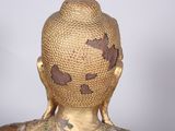 a gold statue of a person with a bird on it ' s head