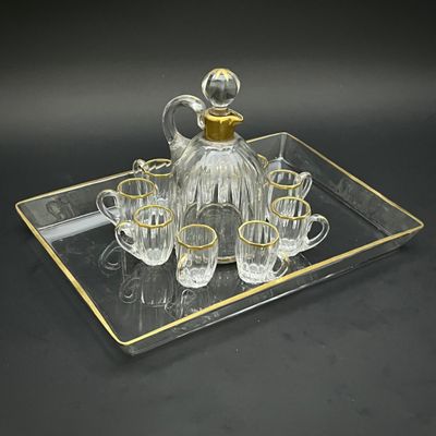 Ensemble de carafe en cristal comprenant quatre verres et une carafe, le tout présenté sur un plateau