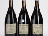 trois bouteilles de vin posées les unes à côté des autres sur une surface blanche